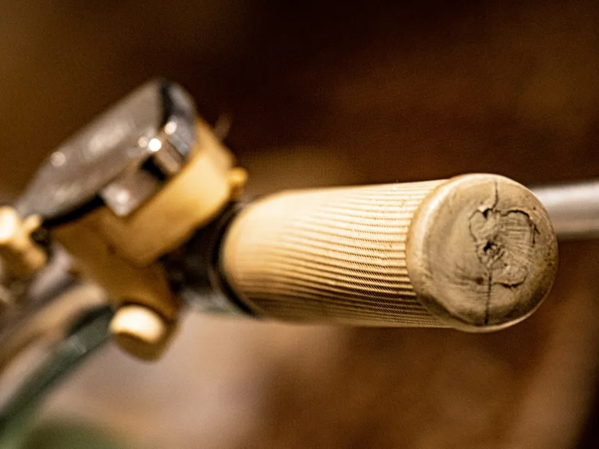 A close-up of a bicycle handlebar with a bell and brake lever, the crowded area where most accessories end up