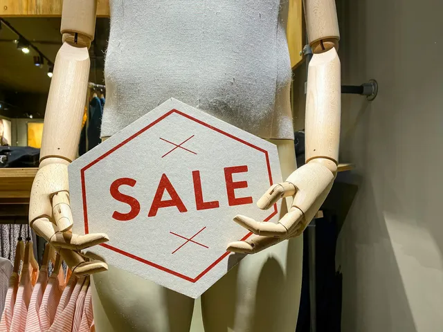 A shop display holding a card printed with the word sale