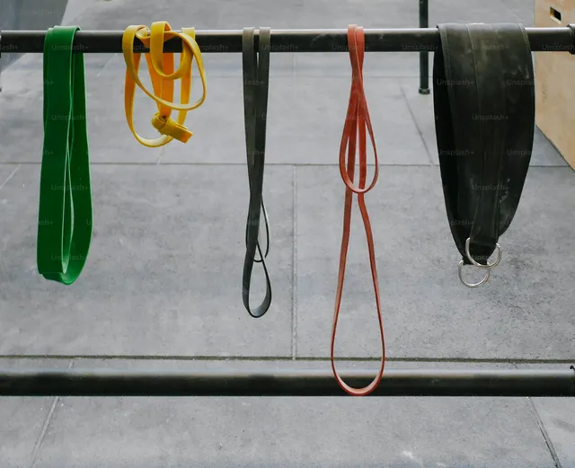 A row of resistance loops and tubes hanging from a metal rail, stored rather than in use